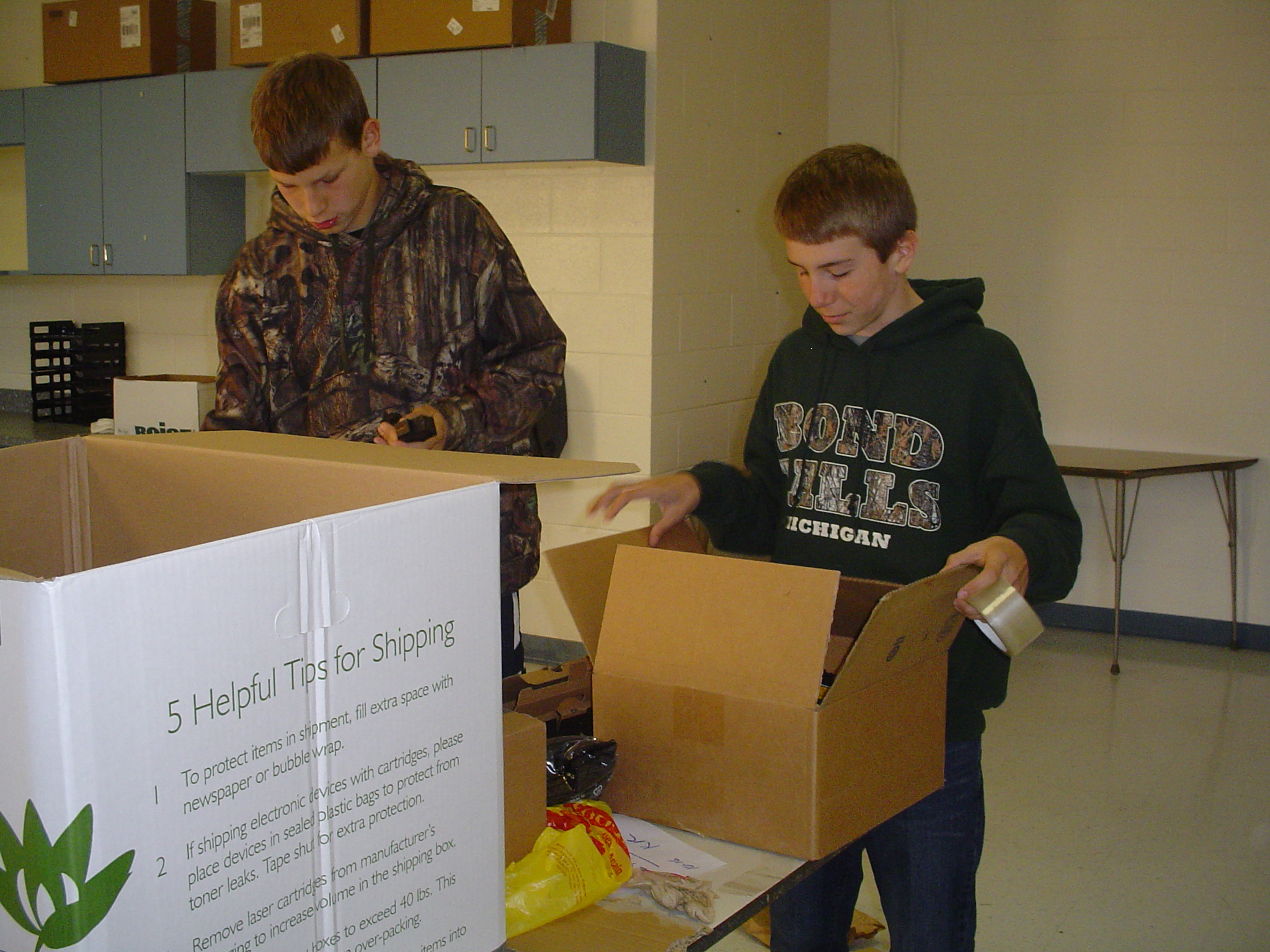 Two Ontonagon students sorting through recyclables and preparing them for shipping